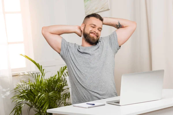Smiling man sitting at workplace — Stock Photo