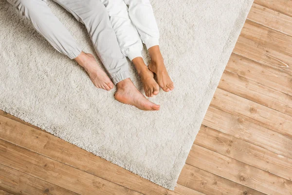 Giovane coppia sdraiata su tappeto a casa — Foto stock