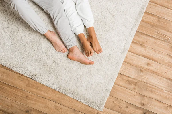 Pareja joven acostada en la alfombra en casa - foto de stock