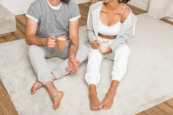 Paar trinkt Kaffee im Sitzen zu Hause — Stockfoto