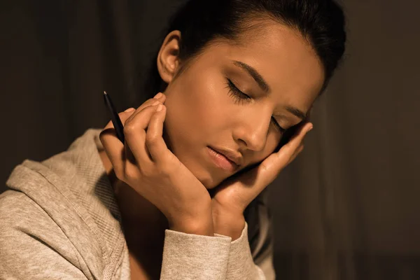 Mujer joven durmiendo mientras está sentada en casa - foto de stock