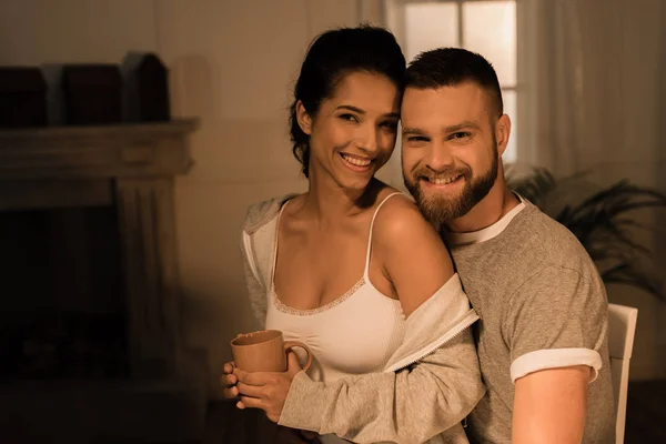 Jeune couple souriant assis ensemble — Photo de stock