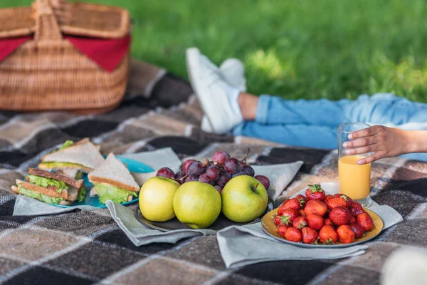 Person trinkt Saft beim Picknick — Stockfoto