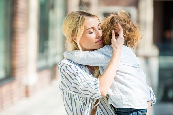 Madre abrazando pequeño hijo - foto de stock