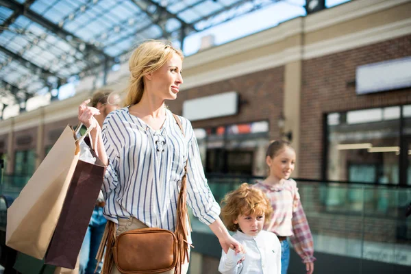 Mère avec des enfants marchant dans le centre commercial — Photo de stock