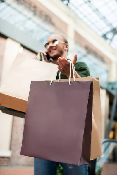Hombre con bolsas de compras en el centro comercial - foto de stock