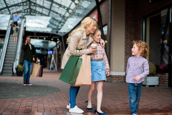 Madre con niños comprando en el centro comercial - foto de stock