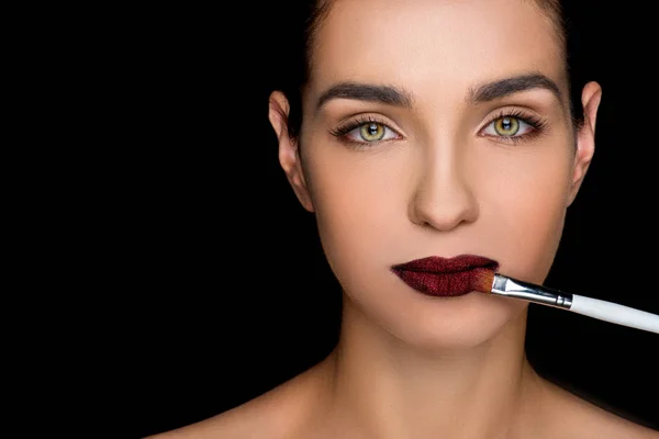 Frau trägt dunklen Lippenstift auf — Stockfoto