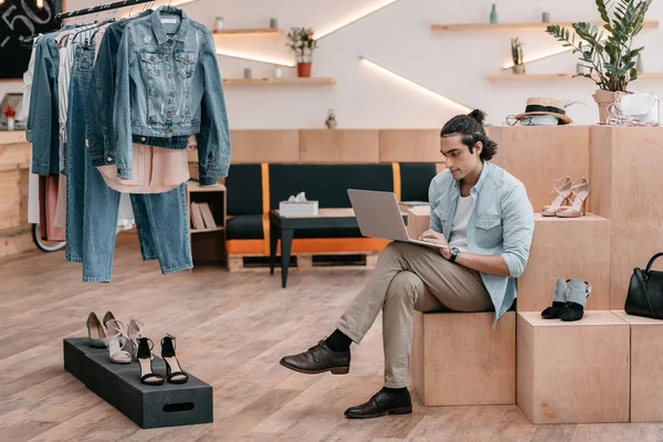 Shop owner using laptop — Stock Photo