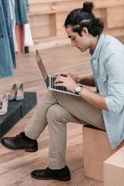 Shop owner using laptop — Stock Photo