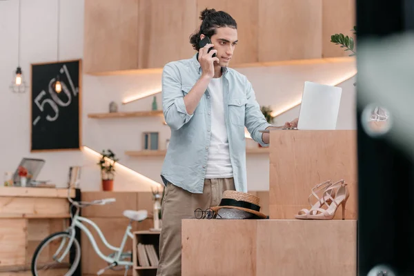 Shop owner talking on smartphone — Stock Photo