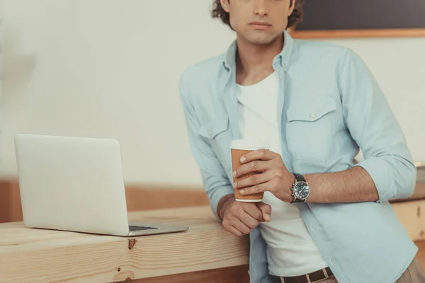 Человек с помощью ноутбука и пить кофе — стоковое фото