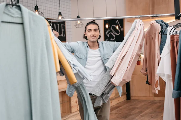 Человек работает с одеждой в бутике — стоковое фото