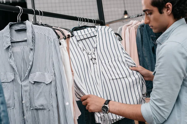 Homme travaillant avec des vêtements en boutique — Photo de stock