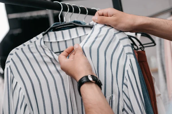 Homem trabalhando com roupas em boutique — Fotografia de Stock