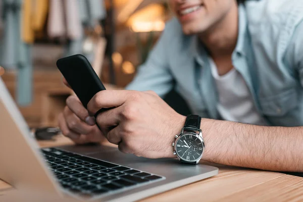 Homem usando laptop e smartphone — Fotografia de Stock