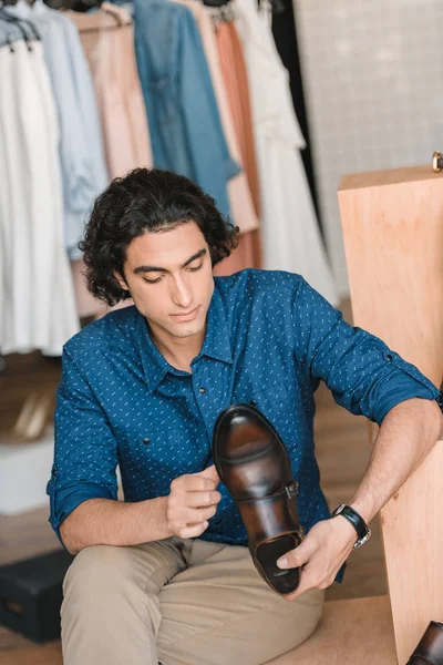 Uomo in possesso di scarpe in boutique — Foto stock