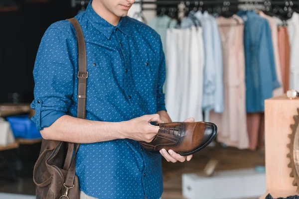 Mann hält Schuh in Boutique — Stockfoto