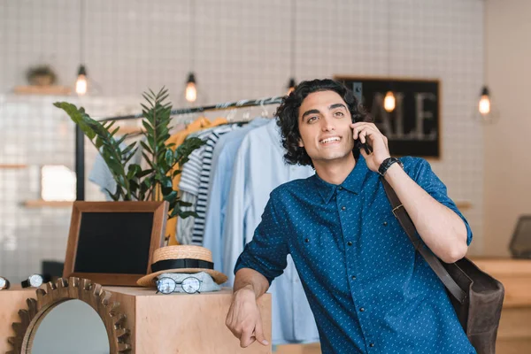 Hombre hablando en el teléfono inteligente durante las compras - foto de stock