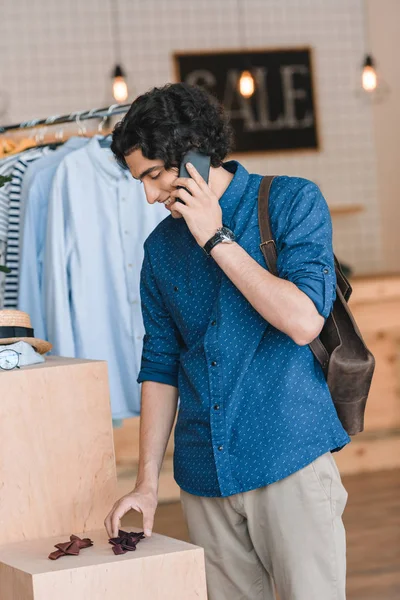 Uomo che parla sullo smartphone mentre fa shopping — Foto stock