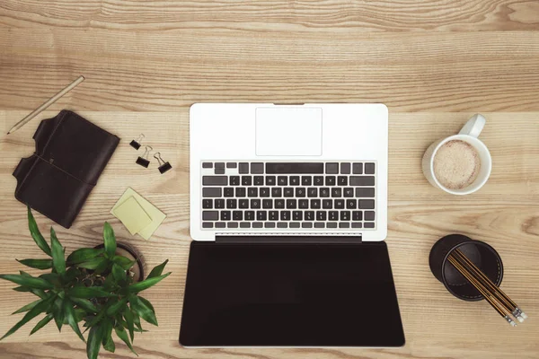 Ordinateur portable avec écran blanc à l'espace de travail — Photo de stock