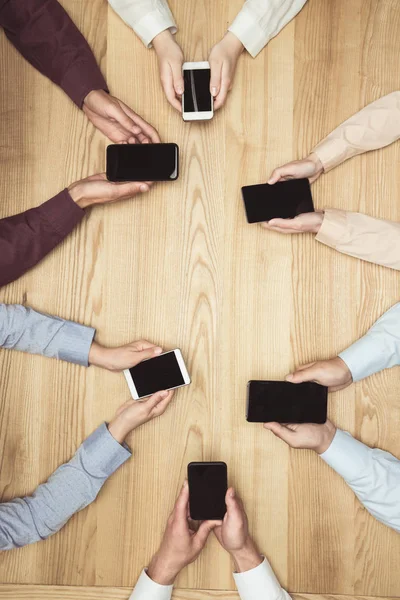 Empresarios con smartphones en reunión - foto de stock