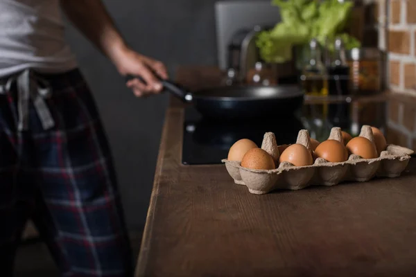 Человек готовит яйца на завтрак — стоковое фото