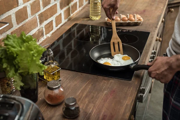 Mann bereitet Eier zum Frühstück zu — Stockfoto