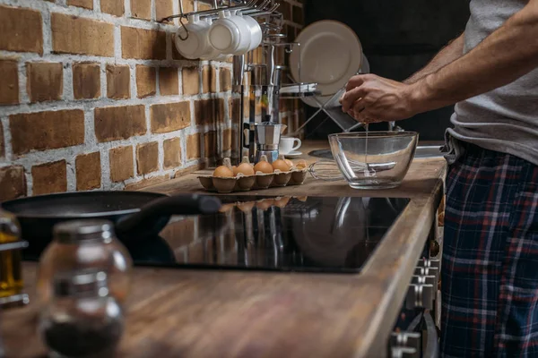 Mann bereitet Eier zum Frühstück zu — Stockfoto