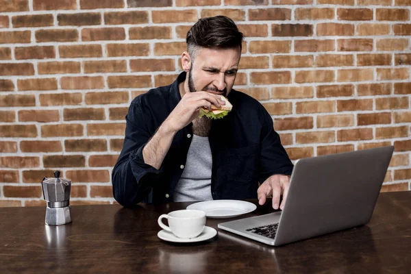 Mann benutzt Laptop beim Frühstück — Stockfoto