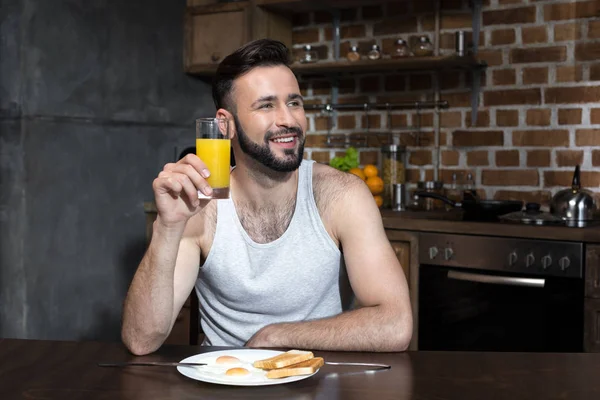 Barbuto giovane uomo bere succo — Foto stock