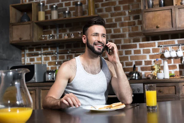 Mann benutzt Smartphone beim Frühstück — Stockfoto