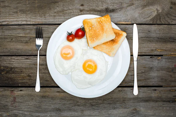 Fried eggs and toasts on plate — Stock Photo