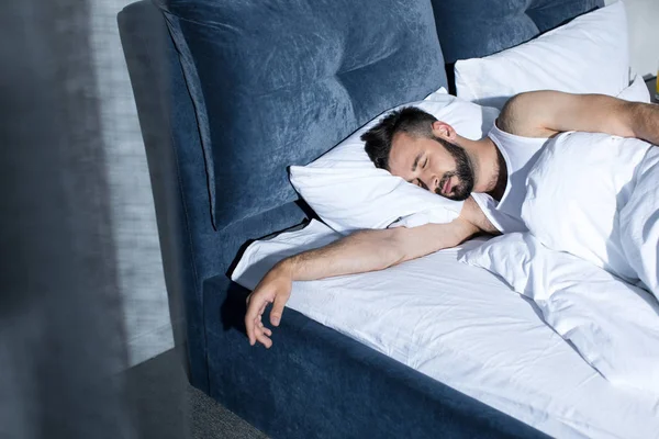 Schöner junger Mann schläft im Bett — Stockfoto