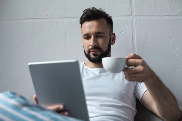 Uomo lettura tablet e bere caffè — Foto stock