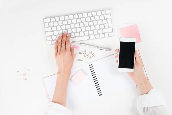 Mulher usando smartphone e teclado — Fotografia de Stock