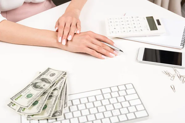 Billetes de mujer de negocios y dólar en el lugar de trabajo - foto de stock