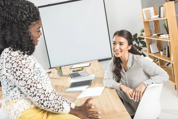 Multiethnic businesswomen having conversation in office — Stock Photo