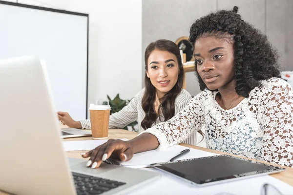 Empresarias multiculturales con portátil - foto de stock