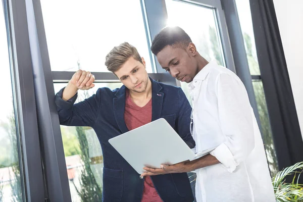 Empresarios multiculturales que trabajan en el ordenador portátil - foto de stock