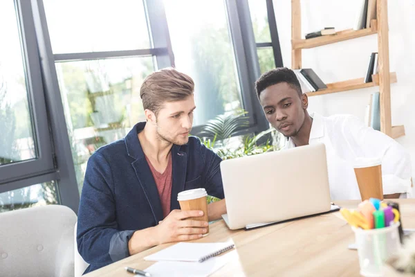 Multicultural businessmen working on laptop — Stock Photo