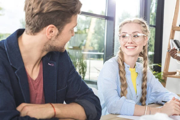 Lächelnde Kollegen unterhalten sich im Büro — Stockfoto