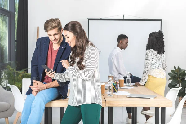 Multicultural business colleagues using smartphone — Stock Photo