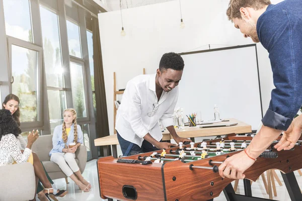 Hombres de negocios multiculturales jugando futbolín - foto de stock