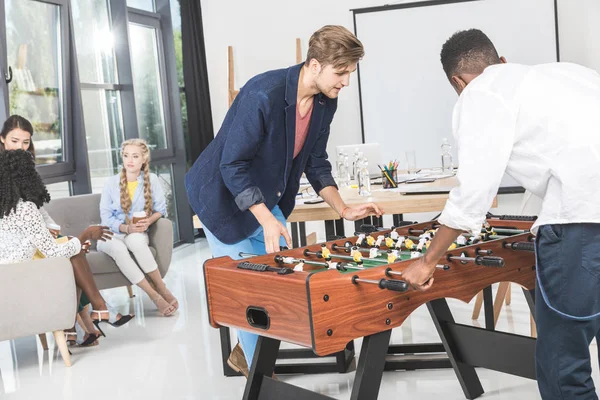 Multicultural businessmen playing table football — Stock Photo