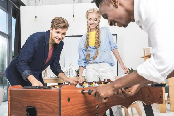 Colegas multiculturais jogando futebol de mesa — Fotografia de Stock