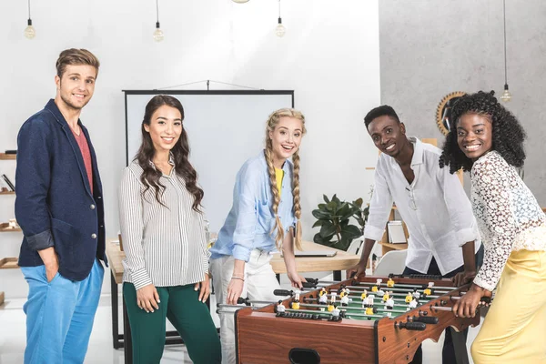 Multicultural colleagues playing table football — Stock Photo