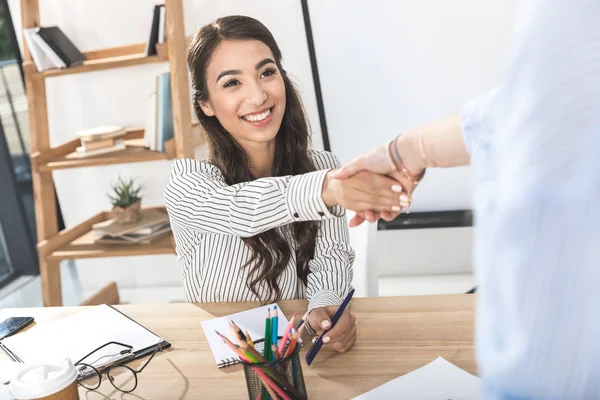 Asiático mujer de negocios estrechando las manos con colega - foto de stock