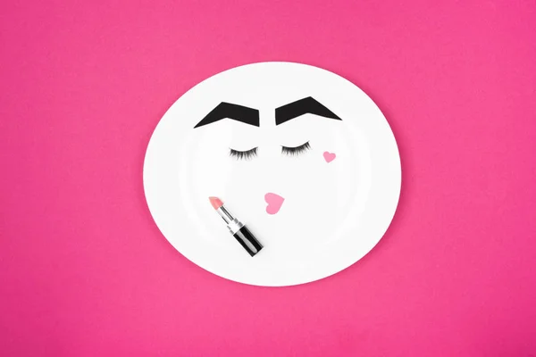 Paper face with makeup on plate — Stock Photo