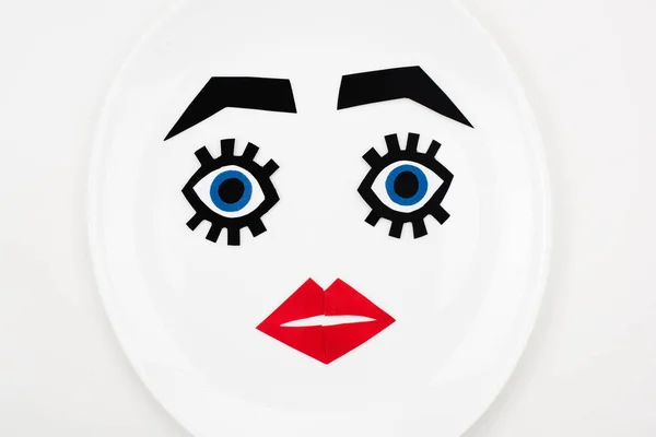 Face de papier avec maquillage sur plaque — Photo de stock